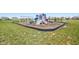 Playground featuring swings and colorful climbing structures; visible pond and nearby residences at 9916 Gallop Ln, Fishers, IN 46040