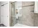 Modern tiled shower featuring glass doors, shelving, and contemporary design at 9916 Gallop Ln, Fishers, IN 46040