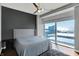 Bedroom featuring a ceiling fan, a large window with city views, and a gray accent wall at 1 Virginia Ave # 707, Indianapolis, IN 46204