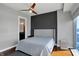 Bedroom featuring a ceiling fan, gray accent wall, hardwood floors, and ensuite bathroom at 1 Virginia Ave # 707, Indianapolis, IN 46204