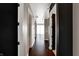 A hallway features dark hardwood floors, dark doors, and access to rooms with white walls at 1 Virginia Ave # 707, Indianapolis, IN 46204