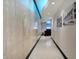 A bright hallway is featured with a marble accent wall, and modern lighting, leading to a reception area at 1 Virginia Ave # 707, Indianapolis, IN 46204