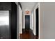 Long hallway with hardwood floors, and dark doors. View to kitchen with stainless appliances at 1 Virginia Ave # 707, Indianapolis, IN 46204
