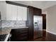 Stylish kitchen with stainless steel fridge, grey backsplash, and dark wood cabinets at 1 Virginia Ave # 707, Indianapolis, IN 46204