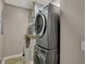 Laundry room featuring a stacked washer and dryer, a utility sink, and tile flooring at 1 Virginia Ave # 707, Indianapolis, IN 46204