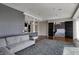 Spacious living room with hardwood floors, stylish gray sofa, and kitchen access with a view to the bedroom at 1 Virginia Ave # 707, Indianapolis, IN 46204