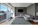 Bright living room with grey sectional, city views, and hardwood flooring at 1 Virginia Ave # 707, Indianapolis, IN 46204