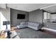 Cozy living room with grey sectional, large TV, and views of the kitchen at 1 Virginia Ave # 707, Indianapolis, IN 46204