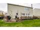 Home's backyard features an elevated wood deck, grill and lush green lawn, perfect for outdoor dining and relaxing at 10220 Tournon Dr, Fishers, IN 46037