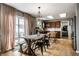 Open dining space featuring a wooden table, access to outdoor patio, and a view of the kitchen at 10220 Tournon Dr, Fishers, IN 46037