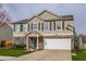 Charming two-story home boasts a well-maintained lawn, attached two-car garage, and a basketball hoop at 10220 Tournon Dr, Fishers, IN 46037