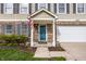 Inviting front porch with blue door, manicured landscaping, and brick accents creates a welcoming entryway at 10220 Tournon Dr, Fishers, IN 46037