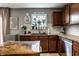 Charming kitchen with dark countertops, wooden cabinets, and window over the sink with decorative plants at 10220 Tournon Dr, Fishers, IN 46037