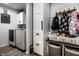 Well-organized laundry room with modern washer and dryer, storage cabinets, and convenient hooks for coats and bags at 10220 Tournon Dr, Fishers, IN 46037