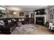 Comfortable living room with a plush leather sectional, fireplace, television, and a colorful patterned rug at 10220 Tournon Dr, Fishers, IN 46037