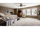 Spacious main bedroom with large windows, ceiling fan, TV, and neutral colors at 10220 Tournon Dr, Fishers, IN 46037