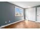 Bright, empty bedroom with hardwood floors, closet space, and a large window at 10533 Williamsburg Dr, Newburgh, IN 47630
