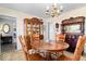 A classic dining room with a wooden table, elegant hutch, and chandelier creates an inviting space at 10533 Williamsburg Dr, Newburgh, IN 47630
