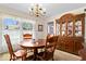 Traditional dining room with wooden table, chairs, and a large china cabinet under a chandelier at 10533 Williamsburg Dr, Newburgh, IN 47630
