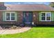 Close-up view of the brick home's entrance featuring a welcoming front door with green trim at 10533 Williamsburg Dr, Newburgh, IN 47630