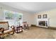 Cozy living room featuring a decorative fireplace, traditional rocking chairs, and soft natural light at 10533 Williamsburg Dr, Newburgh, IN 47630