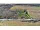 An aerial view of a house nestled on a property with a long driveway and green lawn near farmland at 11015 S State Road 58, Columbus, IN 47201