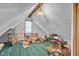 Unfinished attic featuring green carpet and window at 11015 S State Road 58, Columbus, IN 47201
