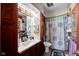 A cozy bathroom with tiled walls, dark wood cabinets, and shower and tub combo at 11015 S State Road 58, Columbus, IN 47201