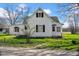 Charming white two-story home with dark shutters, a front yard, and a gravel driveway at 11015 S State Road 58, Columbus, IN 47201
