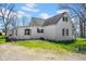 Side view of a two-story white home with dormers, windows, and gravel driveway at 11015 S State Road 58, Columbus, IN 47201