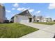 Well-manicured home exterior featuring a two-car garage, concrete driveway, and vibrant green lawn at 11622 Brookwood Trace Dr, Indianapolis, IN 46229