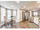 Well-lit dining area with stainless steel appliances and updated flooring at 11674 Buttonwood Dr, Carmel, IN 46033