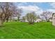 Vast backyard showcasing well-maintained lawn, mature trees, and the house with a screened-in porch at 118 Presidential Ct, Greenfield, IN 46140