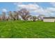 Wide backyard view with green lawn, various trees, and the house, plus a storage shed on the right at 118 Presidential Ct, Greenfield, IN 46140