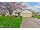 Charming single-story home featuring well-manicured lawn and beautiful flowering tree in a suburban setting at 118 Presidential Ct, Greenfield, IN 46140