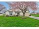 Attractive single-story home featuring green lawn, flowering tree and two car garage in a suburban setting at 118 Presidential Ct, Greenfield, IN 46140