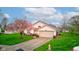 Attractive single-story home with a blossoming tree, well-kept lawn, and paved driveway at 118 Presidential Ct, Greenfield, IN 46140