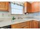 Kitchen sink with wood cabinets, white countertops, and window view at 118 Presidential Ct, Greenfield, IN 46140