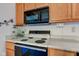 Close-up of the kitchen featuring stove and microwave with ample cabinet space at 118 Presidential Ct, Greenfield, IN 46140