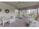 Cozy sunroom with white wicker furniture, a ceiling fan, and sliding glass doors for natural light at 118 Presidential Ct, Greenfield, IN 46140