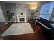 Cozy living room featuring a fireplace, large area rug, and a piano at 12458 Trumbull Ct, Fishers, IN 46038