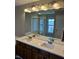 Bathroom featuring a double vanity, wood cabinets, and a large mirror at 12802 Ari Ln, Fishers, IN 46037