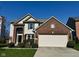 Charming two-story home featuring a brick facade, two-car garage, and well-maintained landscaping at 12802 Ari Ln, Fishers, IN 46037