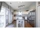 Bright kitchen with white cabinets, stainless steel appliances, granite counters, and an adjacent sliding glass door to deck at 14203 Cliffwood Pl, Fishers, IN 46038