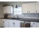 This contemporary kitchen features updated countertops, tile backsplash, stainless steel appliances, and white cabinets at 14203 Cliffwood Pl, Fishers, IN 46038