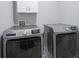 A laundry room with modern, stainless-steel washer and dryer units and a tile floor at 14203 Cliffwood Pl, Fishers, IN 46038
