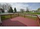 The red back deck overlooks the yard with a white picket fence and playground at 14538 Baldwin Ln, Carmel, IN 46032