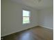 This bedroom features dark wood-look flooring, a window, and neutral walls at 14538 Baldwin Ln, Carmel, IN 46032