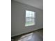 This bedroom features dark wood-look flooring, a window, and neutral walls at 14538 Baldwin Ln, Carmel, IN 46032