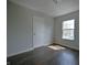 This bedroom features dark wood-look flooring, a window, and neutral walls at 14538 Baldwin Ln, Carmel, IN 46032